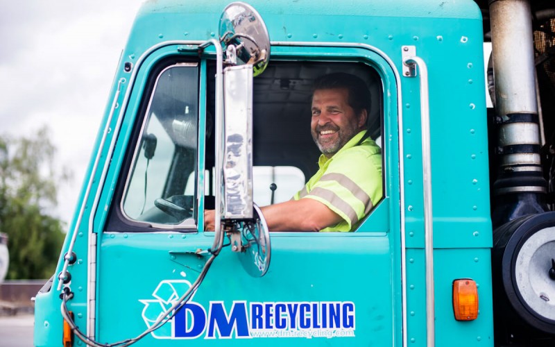 Photo of driver sitting in the cab of a DM Recycling truck.