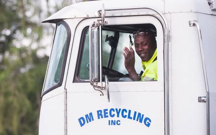 Photo of a driver in the cab of a DM Recycling truck.